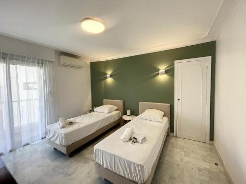 deux lits dans une chambre aux murs verts dans l'établissement Superbe 4 pièces vue mer 320L DEL, à Cannes