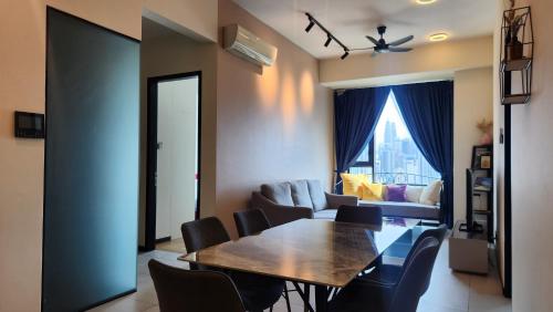 a living room with a table and chairs and a couch at Opus Residences Kuala Lumpur by Infini Suites in Kuala Lumpur