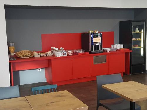 Una cocina roja con una encimera con microondas. en hotelF1 Cergy, en Cergy