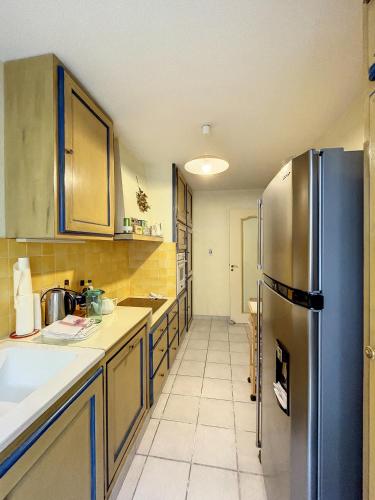une cuisine avec un réfrigérateur en acier inoxydable dans l'établissement Front de mer, superbe terrasse vue mer 283L CHANS, à Cannes