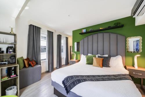 a bedroom with a large bed and a green wall at Claremont Hotel in Miami Beach