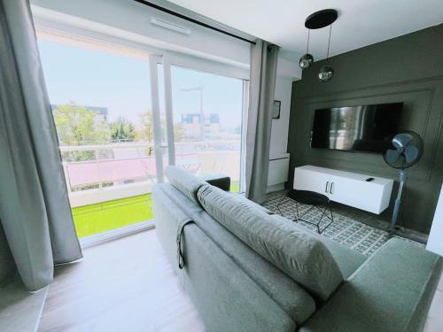 un salon avec un canapé et une grande fenêtre dans l'établissement ModernCosy Près Disneyland Paris, à Noisy-le-Grand