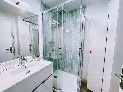a bathroom with a glass shower and a sink at ModernCosy Près Disneyland Paris in Noisy-le-Grand