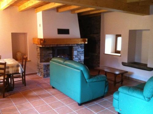 a living room with a blue couch and a fireplace at Maison De Caractère En Pierre cal Batlle in Saint-Pierre-dels-Forcats