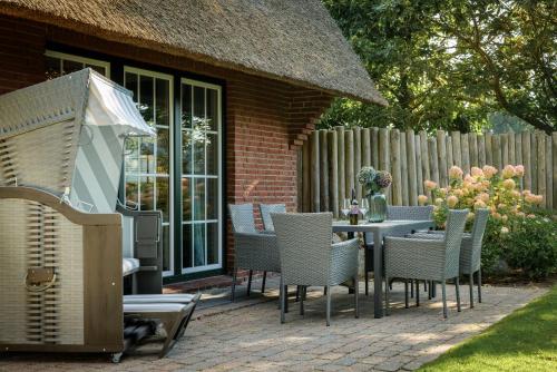 a patio with a table and chairs and a fence at Hotel Reethüüs in Kampen