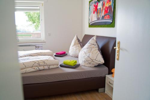 a bedroom with a bed with pillows and a window at Ferienwohnung Little Dragon - Rheinblick in Rees