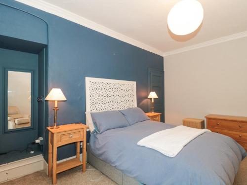 a blue bedroom with a bed and a mirror at Humphreston House in Bristol