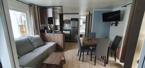 - un salon et une salle à manger avec un canapé et une table dans l'établissement Mh789 Bois Dormant sans vis à vis, à Saint-Jean-de-Monts