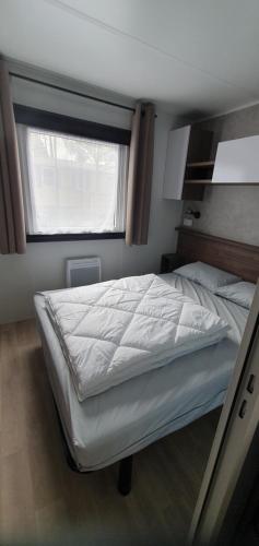 une chambre avec un grand lit avec une fenêtre dans l'établissement Mh789 Bois Dormant sans vis à vis, à Saint-Jean-de-Monts