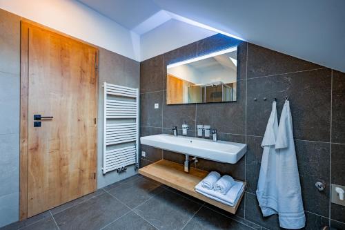 a bathroom with a sink and a mirror at PENZIÓN u JAKUBA & REŠTAURÁCIA Bezplatné Parkovanie in Martin