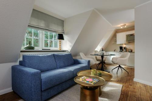 a living room with a blue couch and a table at Hotel Reethüüs in Kampen