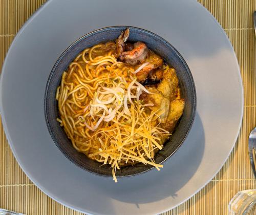 a bowl of noodles on a plate on a table at MareCoves Resort & Glamping in Cilangkahan