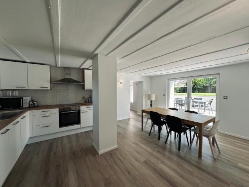 une cuisine et une salle à manger avec une table et des chaises dans l'établissement Le Parc 96 - Gîte aux Portes de Colmar, à Wintzenheim