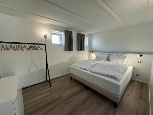 une chambre avec un lit dans une pièce blanche dans l'établissement Le Parc 96 - Gîte aux Portes de Colmar, à Wintzenheim