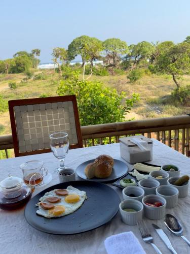 a table with two plates of eggs and food on it at MareCoves Resort & Glamping in Cilangkahan