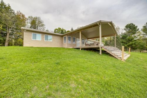 a home with a large yard with a house at Waterfront Evart Getaway with Fire Pit on 82 Acres! in Evart