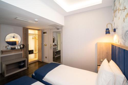 a bedroom with a white bed and a mirror at Querencia Hotel in Istanbul
