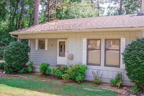 una piccola casa con porta bianca e finestre di 31 Reddina Lane a Hot Springs Village
