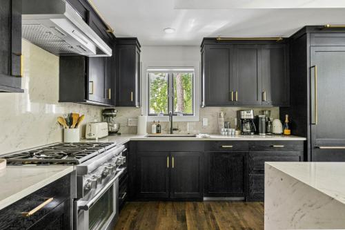 a kitchen with black cabinets and a stove at Living My Best Life in Union Pier