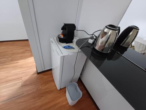 a desk with a phone and a coffee maker on it at Villa Vamus Vendég- és RendezvényHáz in Vámosszabadi