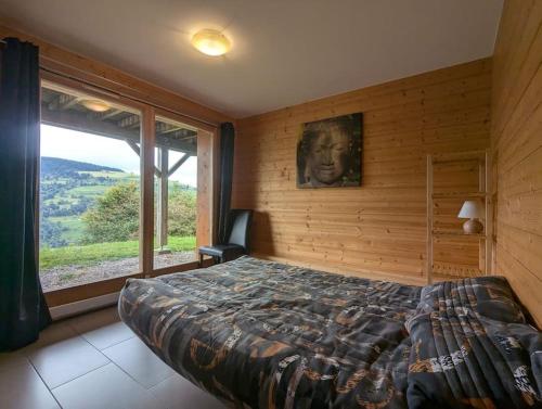 a bedroom with a bed and a large window at Le Grand Chalet Bellevue - parking Wifi BBQ in La Bresse