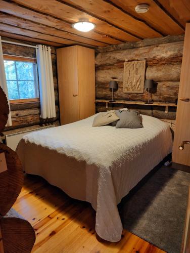 a bedroom with a bed in a log cabin at Isokelo Log Apartments in Salla