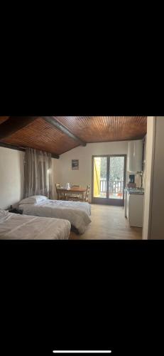 Cet appartement comprend une chambre avec deux lits et une cuisine avec une table. dans l'établissement Appartement chaleureux, à La Bollène-Vésubie