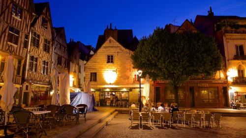 Un groupe de personnes assises à des tables dans une rue la nuit dans l'établissement Le Jardin De Guilbaud - Hypercentre - Netflix, à Tours