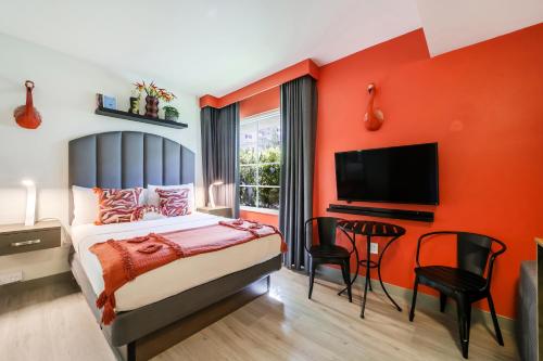 a bedroom with a bed and a flat screen tv at Claremont Hotel in Miami Beach