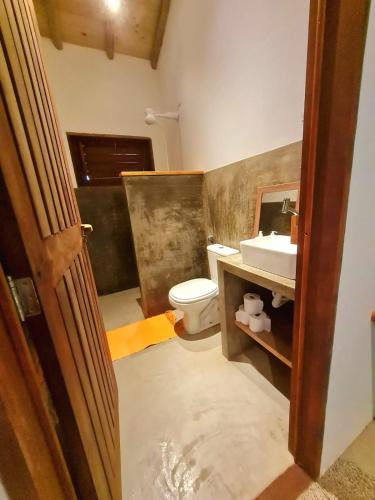 a bathroom with a toilet and a sink at Chalés Mahalo J - Pontal de Maceió - Fortim in Fortim