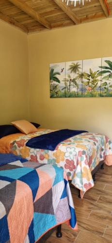 two beds sitting next to each other in a room at Habitaciones y Cabañas El Sauce in Tela