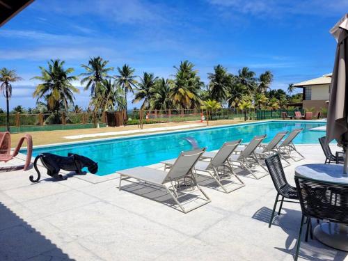 a dog is standing next to a swimming pool at Bangalô Exclusivo A6 Imbassaí Privilege Beira Mar in Imbassai