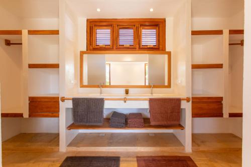 un baño con lavabo y espejo en Villa Continentes Brasil & Maison de rêve sur la plage, en Guajirú
