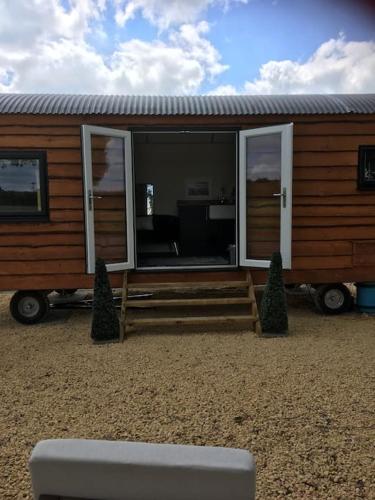 a tiny house with a porch and sliding glass doors at Shepherds Haven in Draycott in the Moors