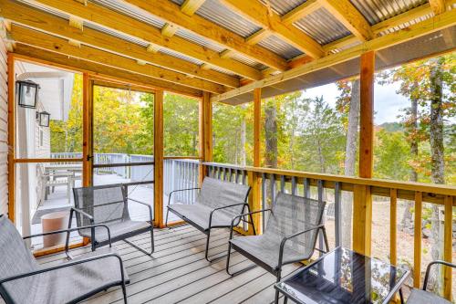 a screened porch with chairs and a table at Mtn Views and Fire Pit Eureka Springs Home in Eureka Springs