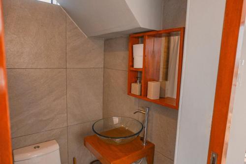 a bathroom with a glass bowl on a table next to a toilet at Che Lobitos in Lobitos