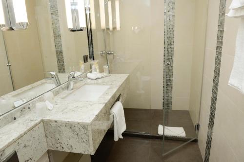 a bathroom with a sink and a shower at Best Western Plus Hotel Sydney Opera in Paris