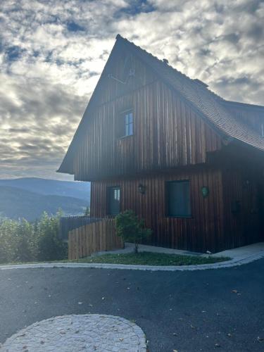 a large wooden house with a gambrel roof at Wellnessalmhaus in Kloster