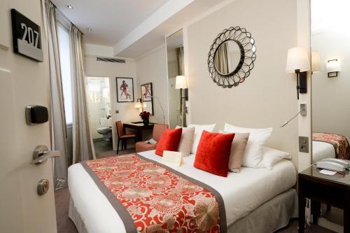 a hotel room with a large bed with red pillows at Best Western Plus Hotel Sydney Opera in Paris