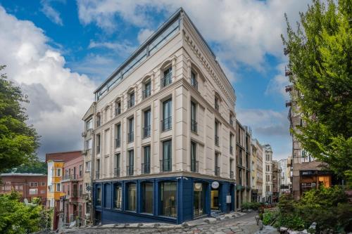 a white building with blue trim on a city street at Querencia Hotel in Istanbul