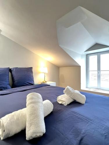 - 2 serviettes sur un lit bleu dans une chambre dans l'établissement Puy duFou 15 min T3 L'étape du Panache, à Sevremont