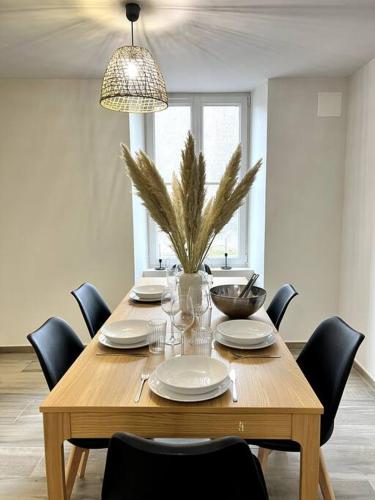 une table à manger avec des chaises et une table en bois avec des assiettes dans l'établissement Puy duFou 15 min T3 L'étape du Panache, à Sevremont