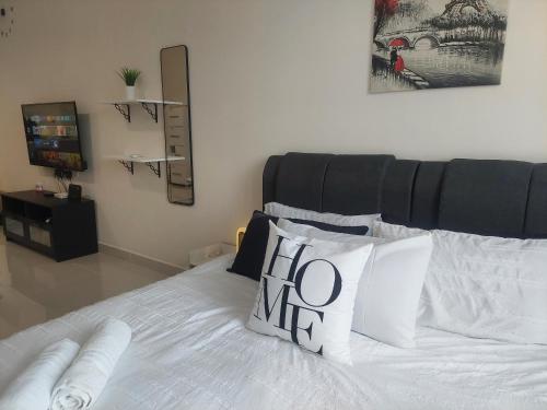 a bedroom with a white bed with a hello me pillow at KLIA Travel Homestay - 3R 2B - WIFI & NETFLIX in Sepang
