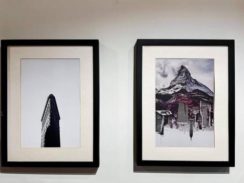 two framed pictures on a wall with a mountain at Stylish Studio Dave Apt Depok with Pool, WiFi, Netflix by 2ndHome in Pondoktjina Tiga