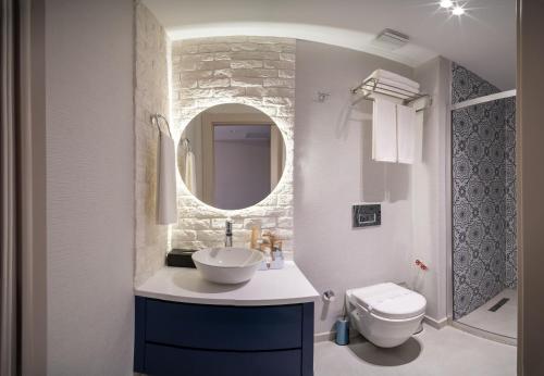 a bathroom with a sink and a toilet and a mirror at Querencia Hotel in Istanbul