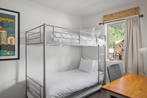 two bunk beds in a room with a desk at Telluride Resort View at Double Diamond - ski-in-out and hot tub! in Telluride