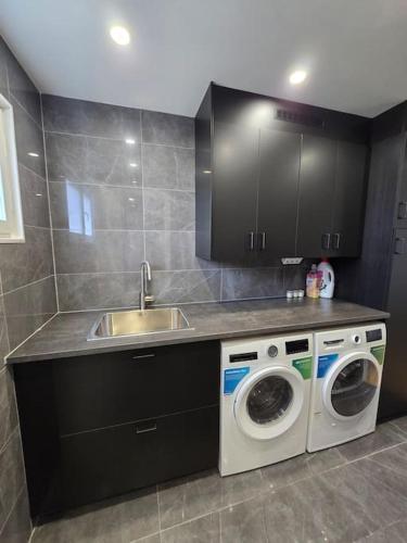 a kitchen with a sink and a washing machine at Modern and complete House in Västerås