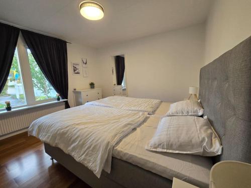 a bedroom with a large bed with white sheets at Modern and complete House in Västerås