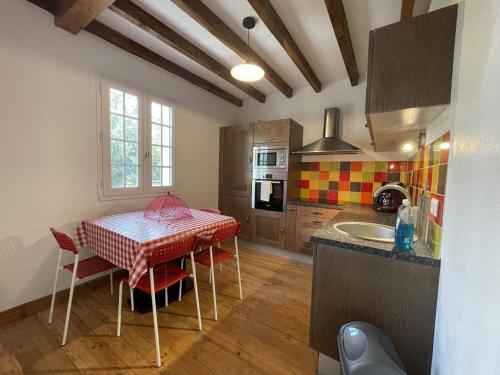 une cuisine avec une table et des chaises dans une cuisine dans l'établissement Elizako bidea, à Mendive