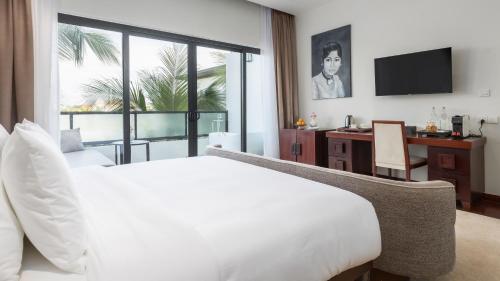a bedroom with a bed and a desk with a computer at Shintana Saya La Maison in Siem Reap